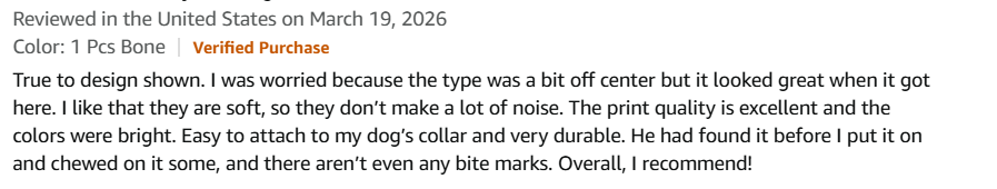 Verified Amazon review: "Bright, Soft and Easy to See" — the reviewer explains that her previous metal tag clinked and banged against bowls, scaring her dog. The new silicone tag is bright, lightweight, thick durable rubber, and the print is clear and easy to see.