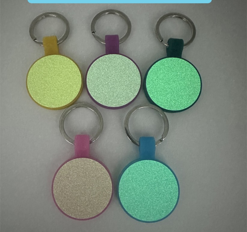 Five round glow-in-the-dark silicone pet ID tags glowing in the dark, different edge colors